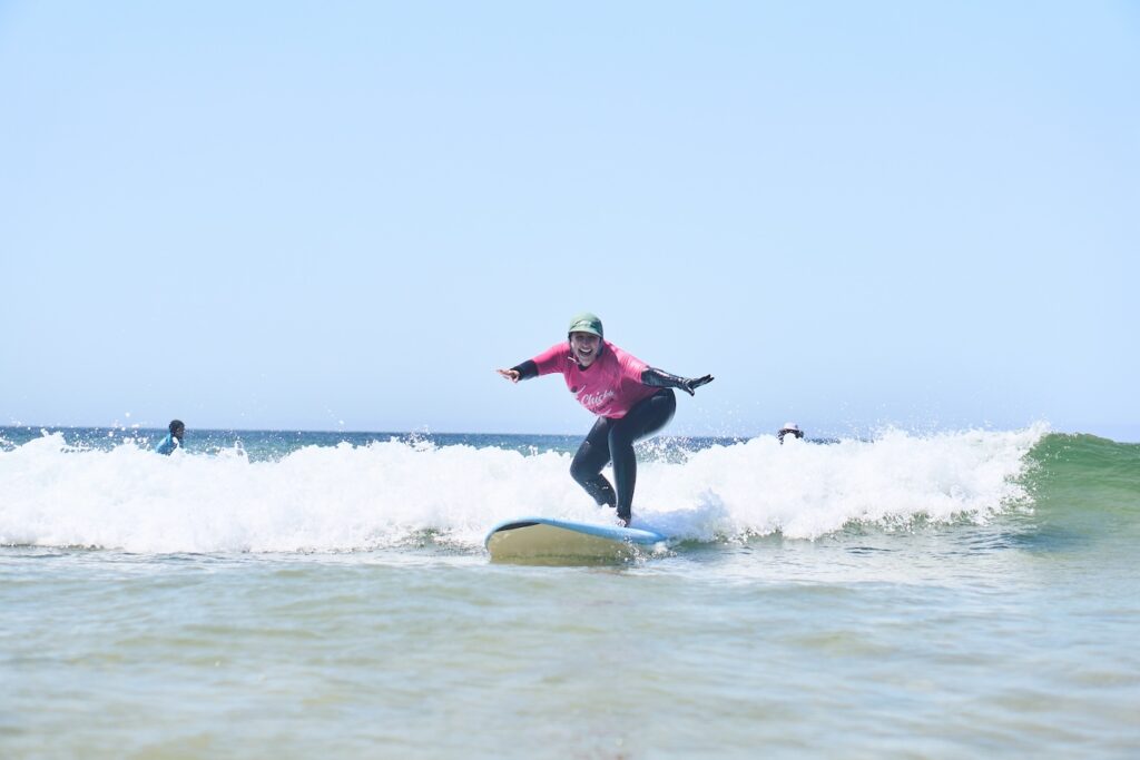 A girl surfing on a Chicks on Waves retreat